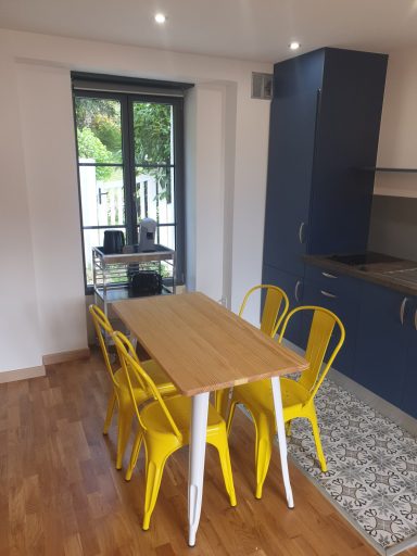 Table en bois avec chaises jaunes dans une cuisine moderne au clair de lune.